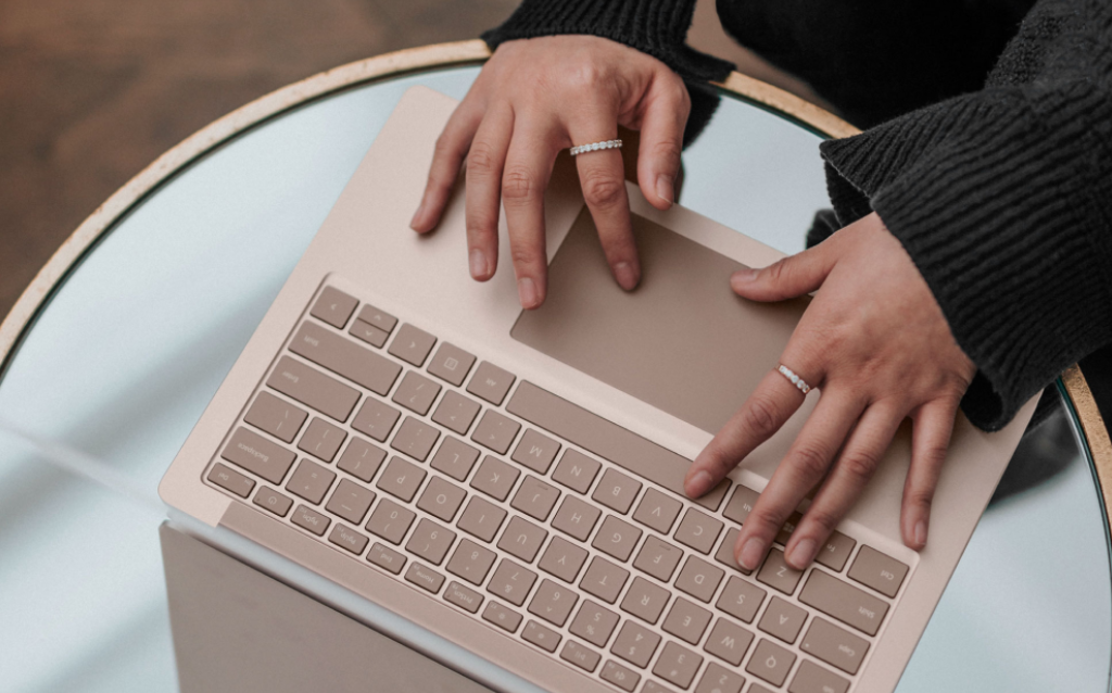 Mulher mexendo no computador e pesquisando como ter uma renda de 5 mil reais