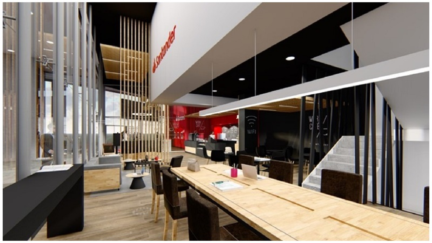 Mesa compartilhada para trabalho com notebook no Work Café Santander, com cafeteria ao fundo